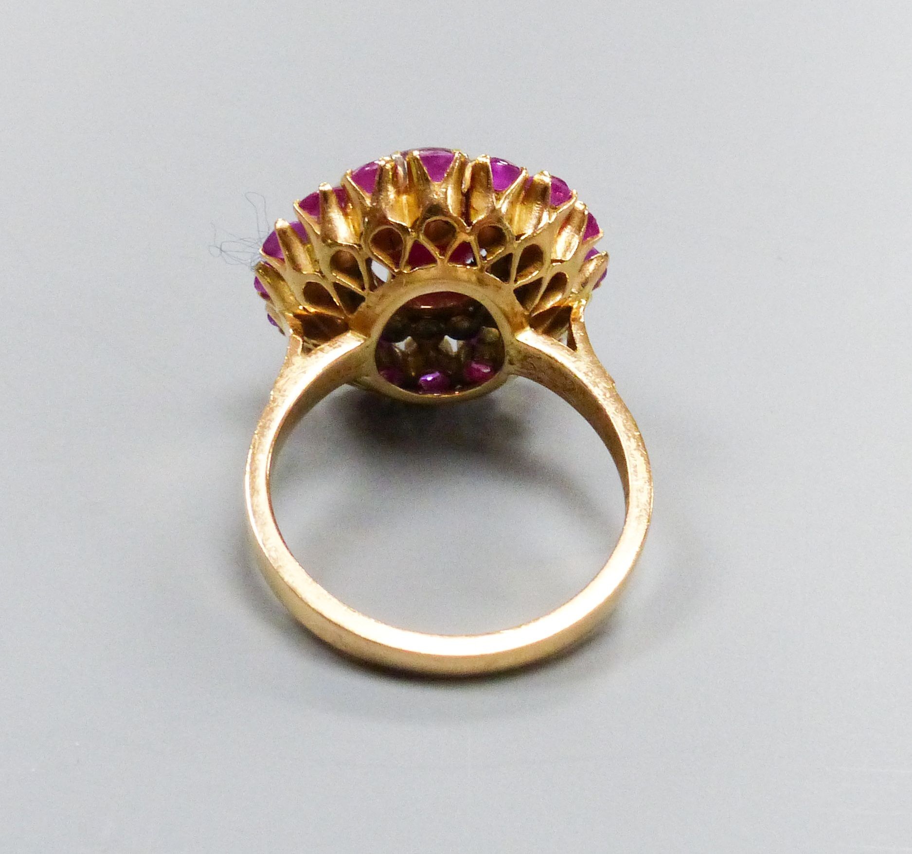 An Indian yellow metal, cabochon ruby and diamond cluster ring, size N, gross weight 8.3 grams, (central stone cracked).